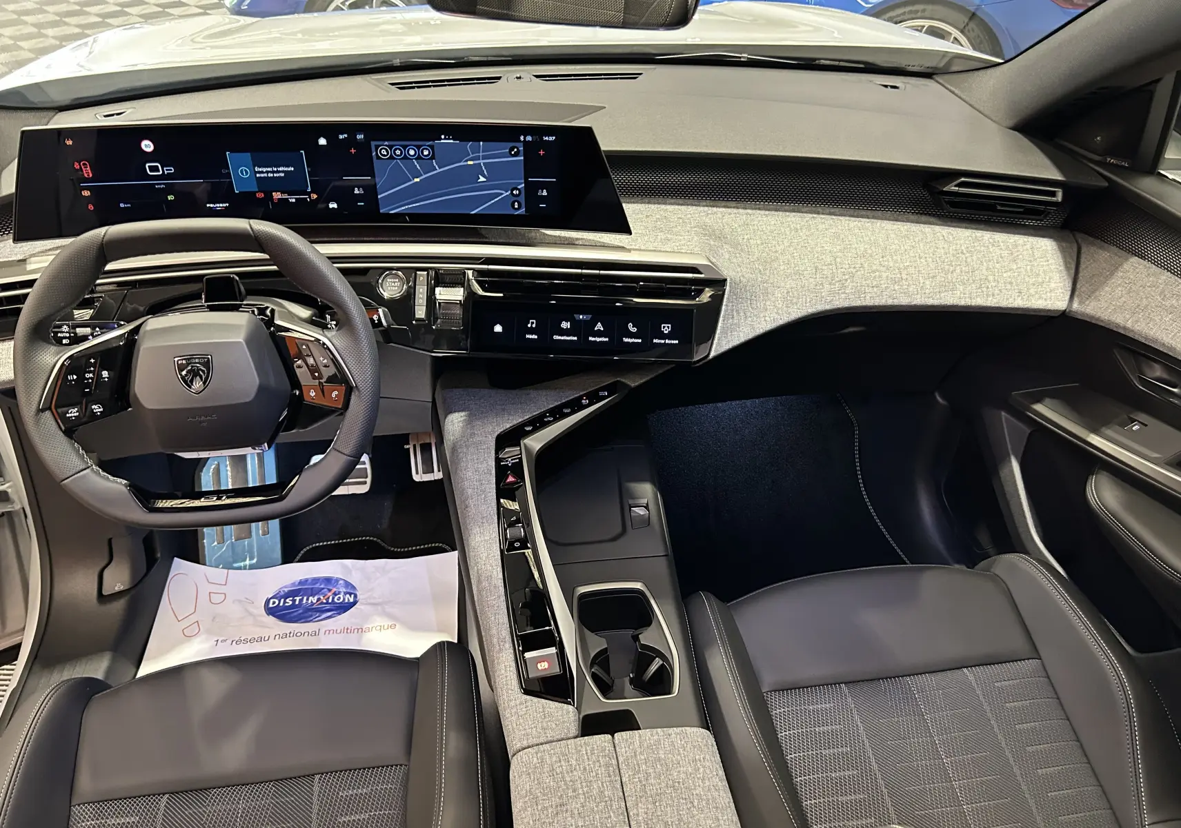 Vue intérieure avant du Peugeot 3008 Hybrid blanc Okenite, mettant en valeur le tableau de bord numérique et la console centrale moderne.