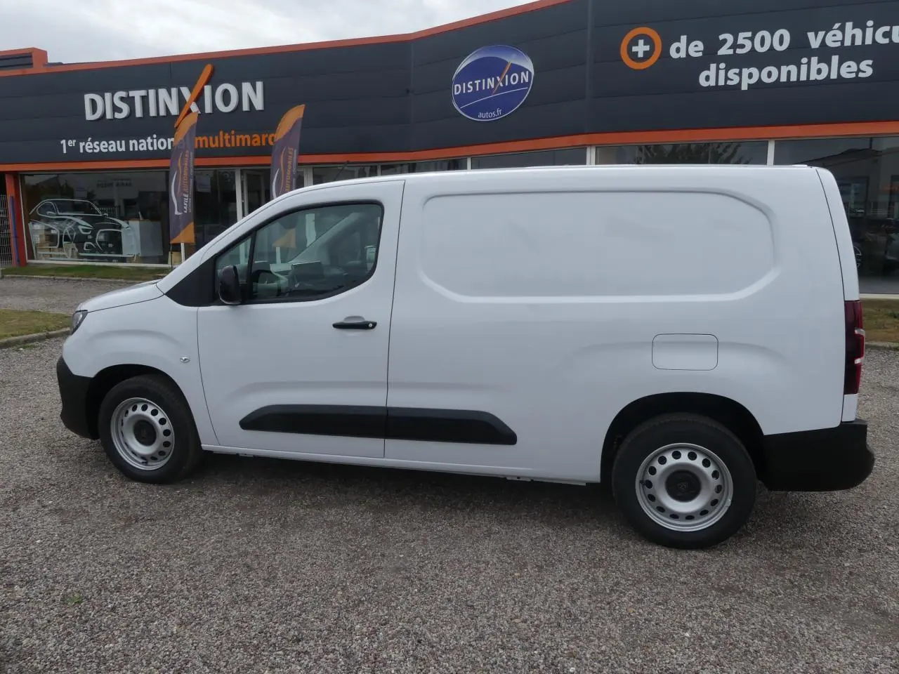Vue de profil côté gauche d'un utilitaire Peugeot Partner blanc avec porte latérale coulissante et jantes tôle grises.