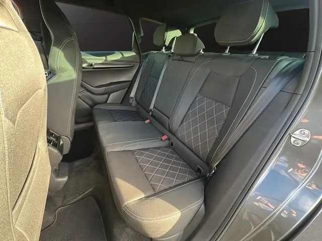 Vue latérale intérieure du siège arrière en tissu noir avec surpiqûres croisées du Skoda Karoq gris graphite 2025 Sportline.