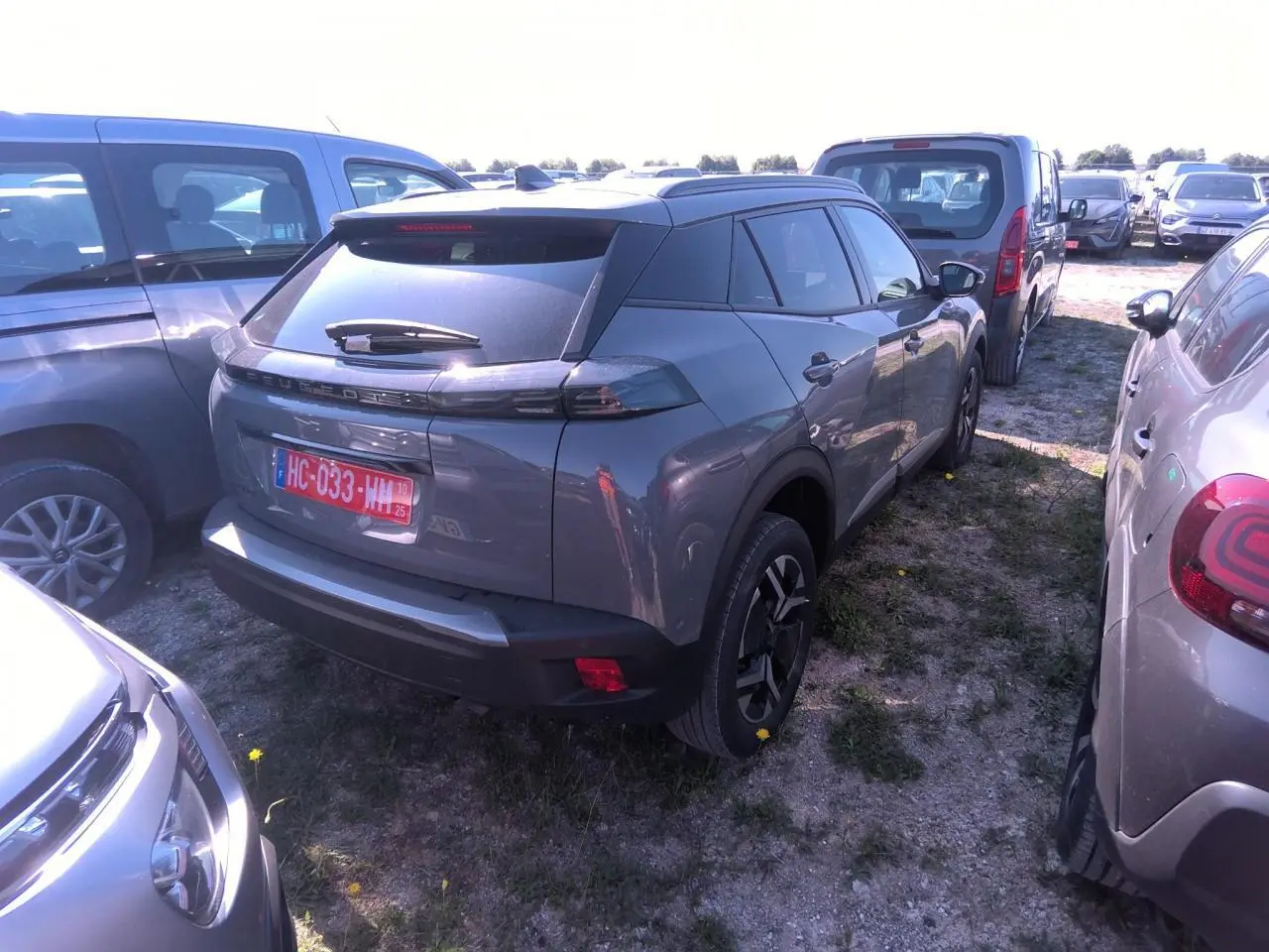 Peugeot 2008 gris clair vue 3/4 arrière droit, avec feux arrière LED et jantes alliage noires.