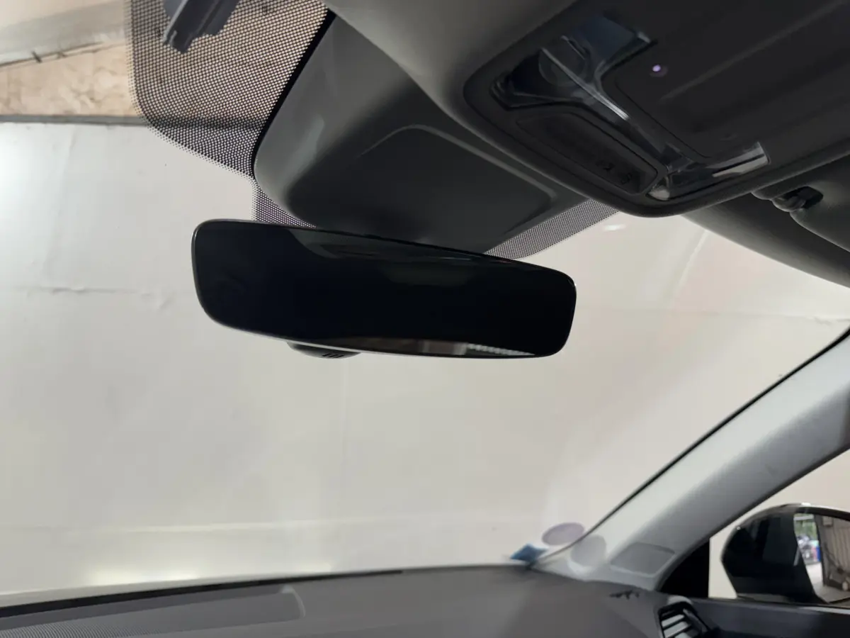 Rétroviseur intérieur noir vu de dessous dans l'Audi Q3 35 TFSI 2022, avec toit clair et pare-brise visible.
