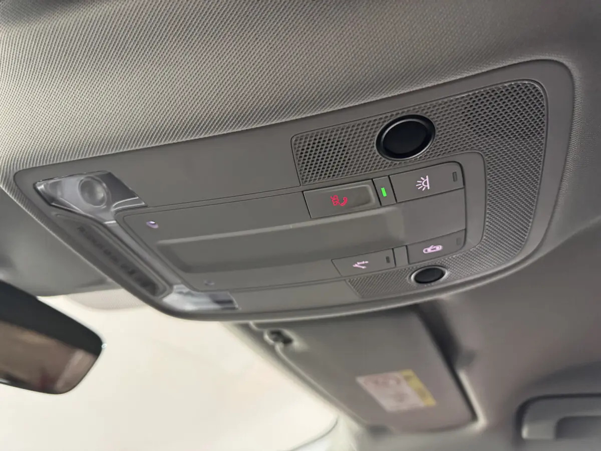 Vue en gros plan du plafonnier gris avec commandes d'éclairage et assistance dans l'Audi Q3 noir 2022.