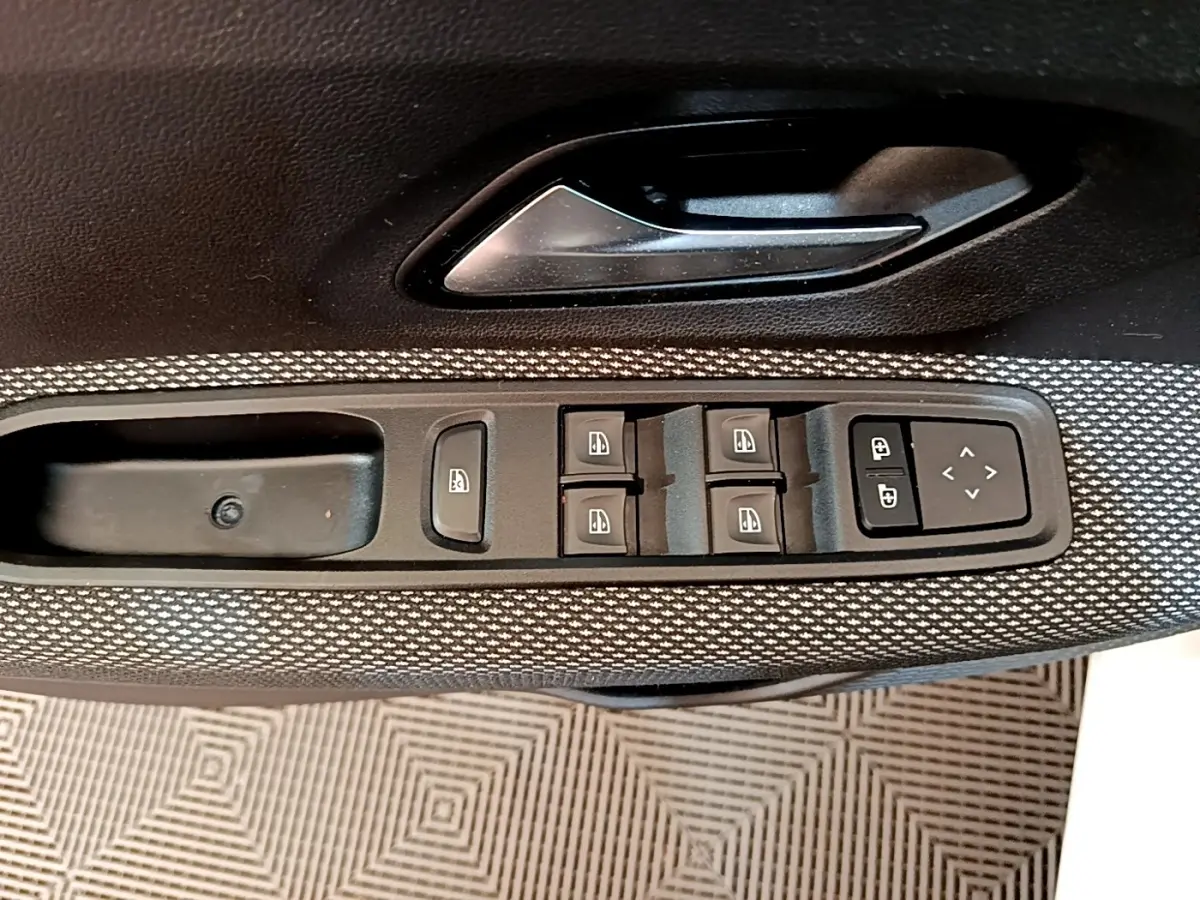 Gros plan sur la commande des vitres électriques et des rétroviseurs sur la porte côté conducteur d'une Dacia Sandero Confort TCe 90 2022.