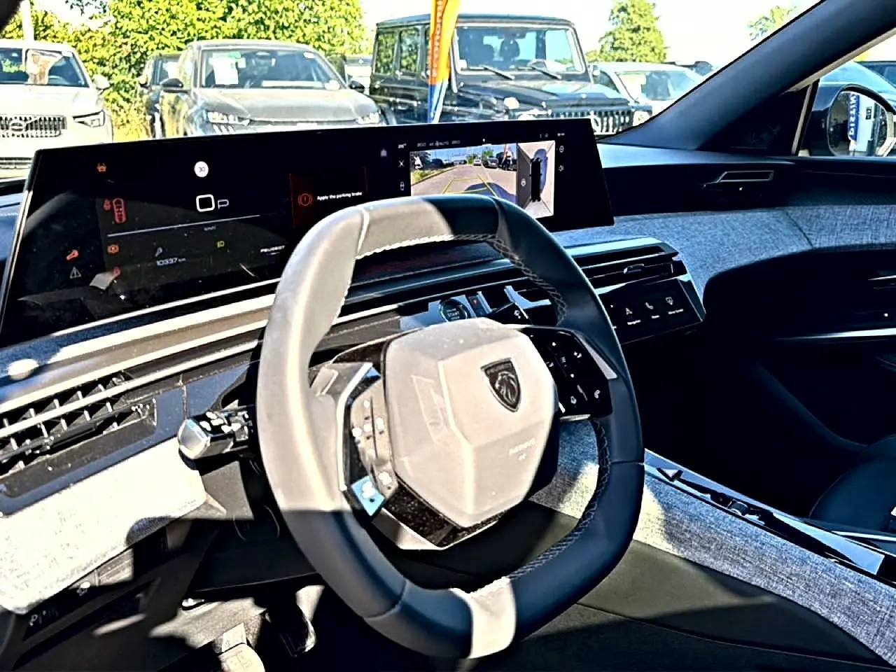 Vue intérieure côté conducteur du Peugeot 3008 2025 avec volant cuir et écran tactile panoramique.