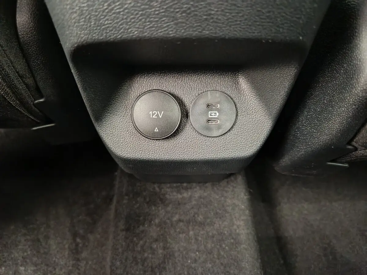 Prise 12V et double port USB-C pour recharge, vue rapprochée de la console arrière du Ford Puma bleu 2025.