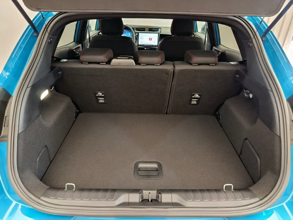 Coffre ouvert d'un Ford Puma bleu 2025, vue arrière, avec sièges arrière et écran tactile visible à l'avant.