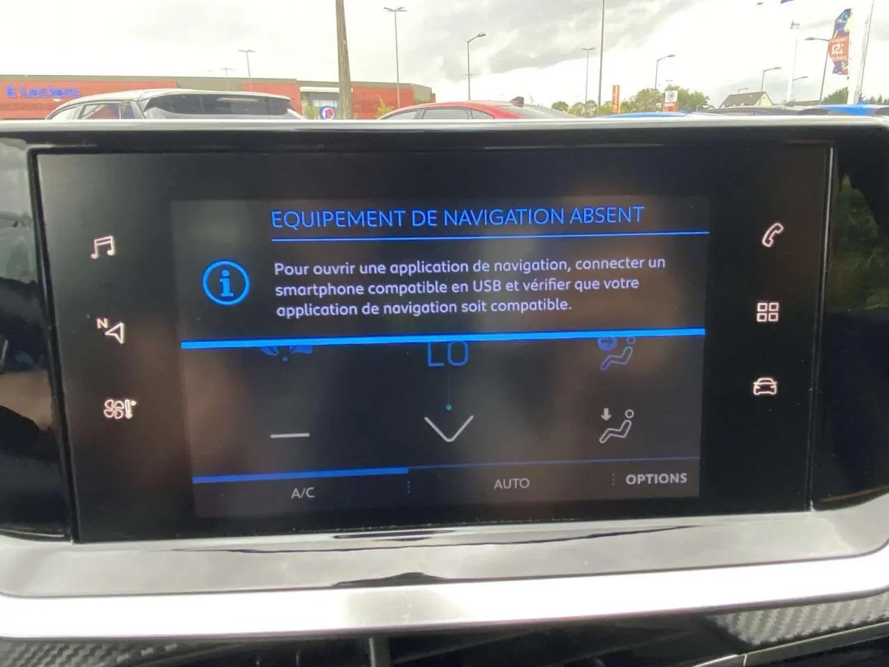 Écran tactile central de la Peugeot 208 bleu 2020 affichant un message d'absence d'équipement de navigation.