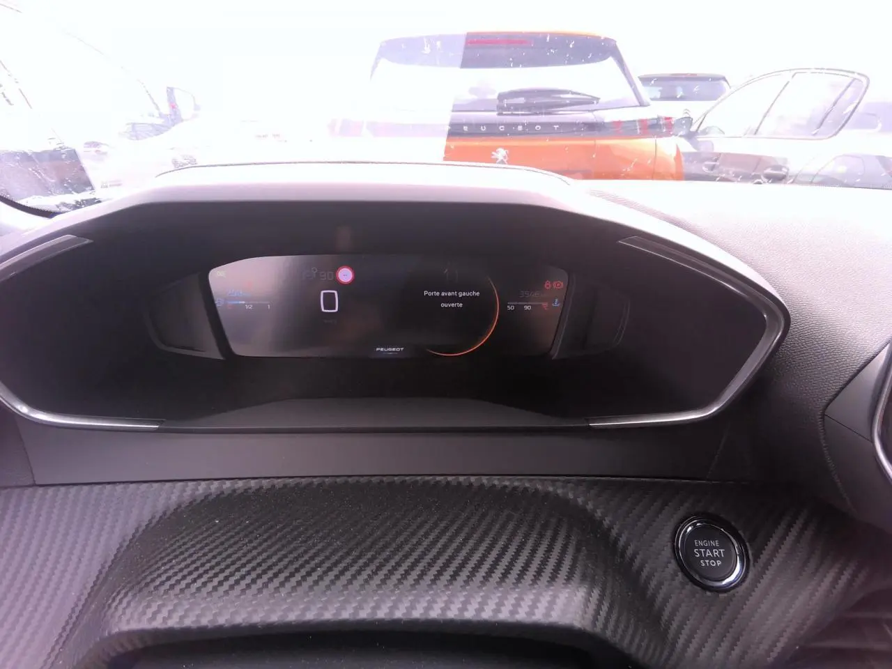 Vue intérieure du tableau de bord numérique du Peugeot 2008 avec bouton Start/Stop et décor carbone.