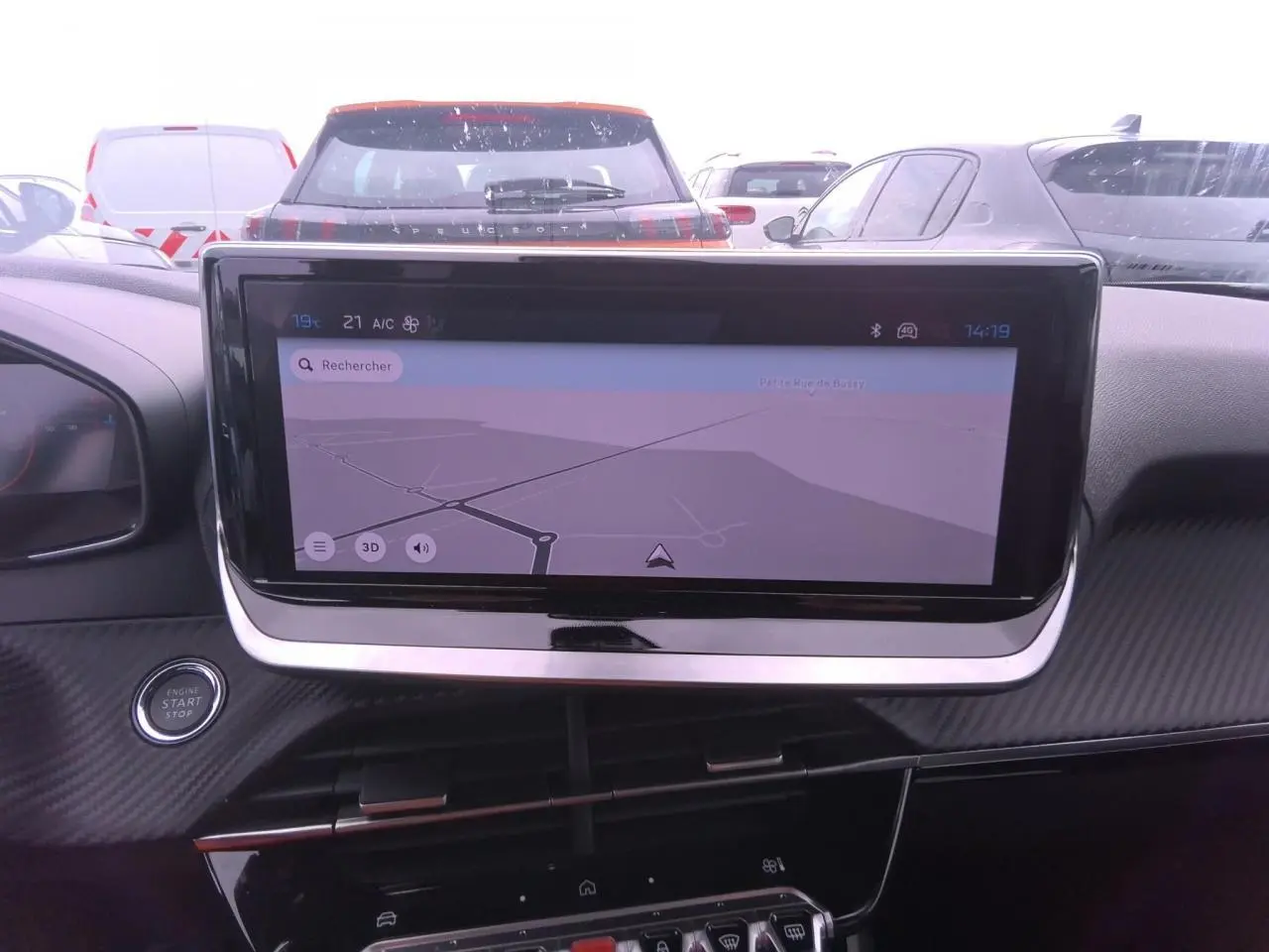 Vue intérieure centrée sur l'écran tactile du système de navigation d'une Peugeot 2008 gris clair, avec tableau de bord noir.