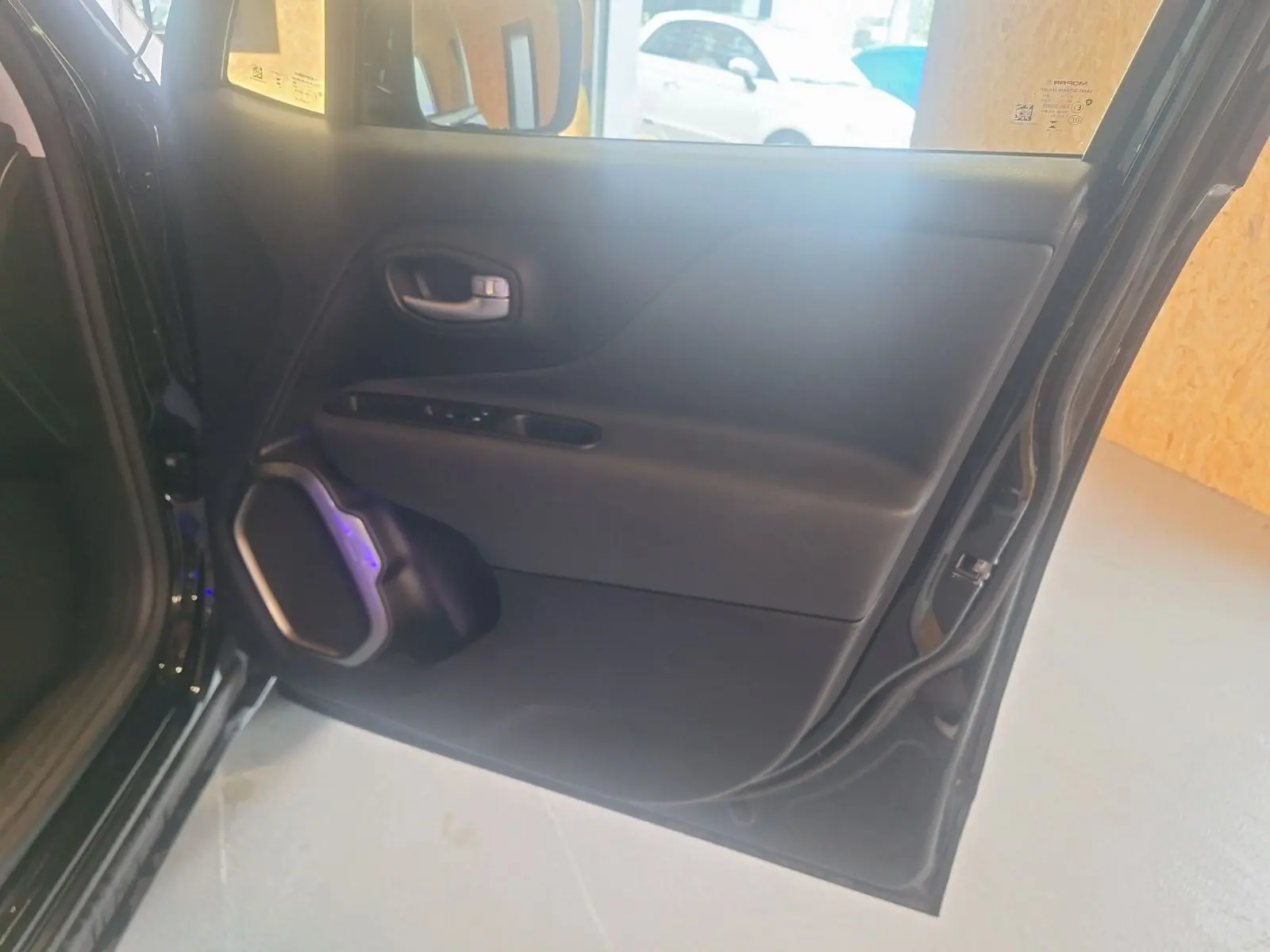 Porte arrière droite noire de Jeep Renegade 2024 avec haut-parleur intégré et commandes de fenêtre visibles.