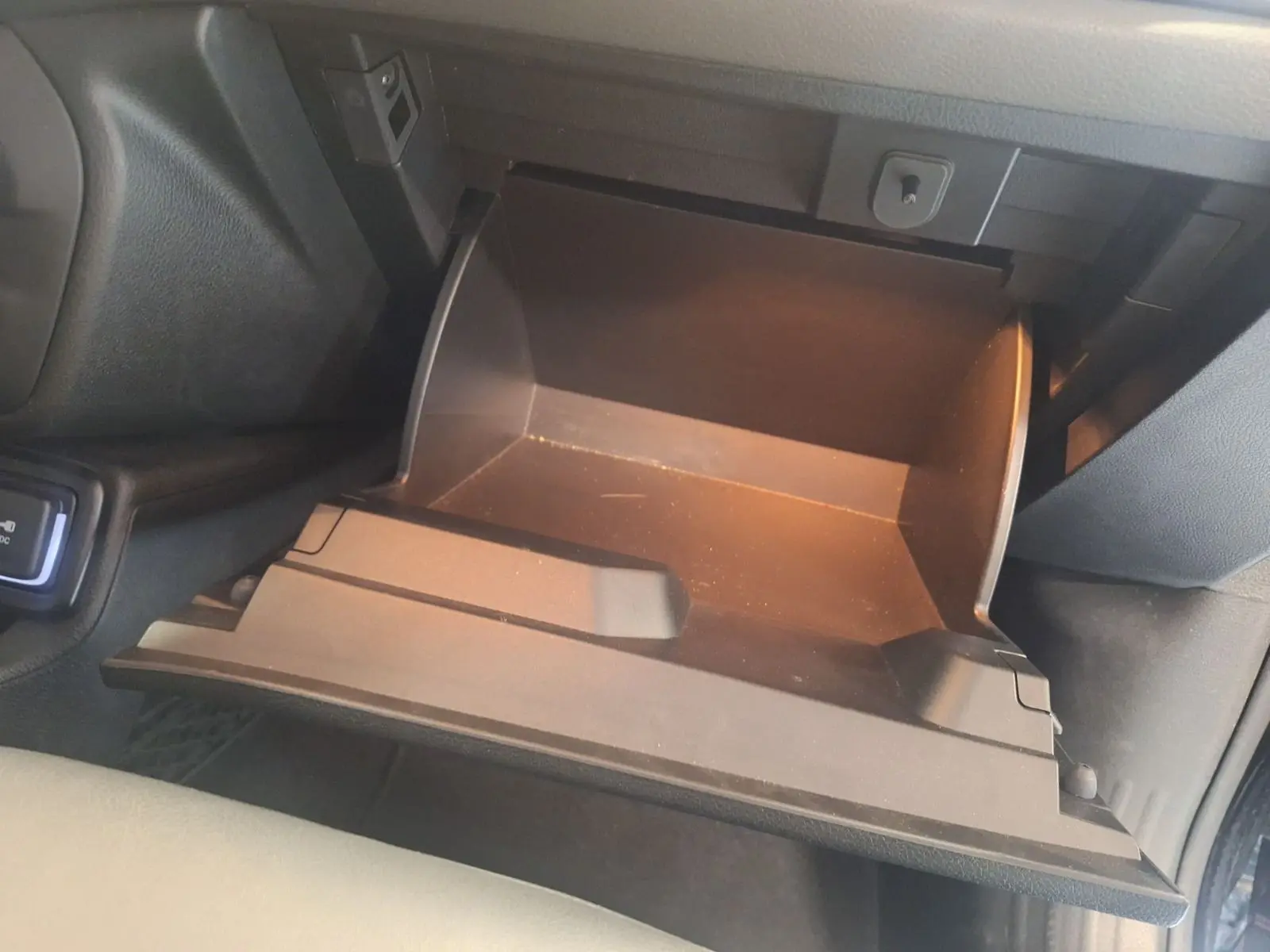 Gant de rangement ouvert côté passager du Jeep Renegade noir 2024, intérieur sombre avec éclairage intérieur doux.