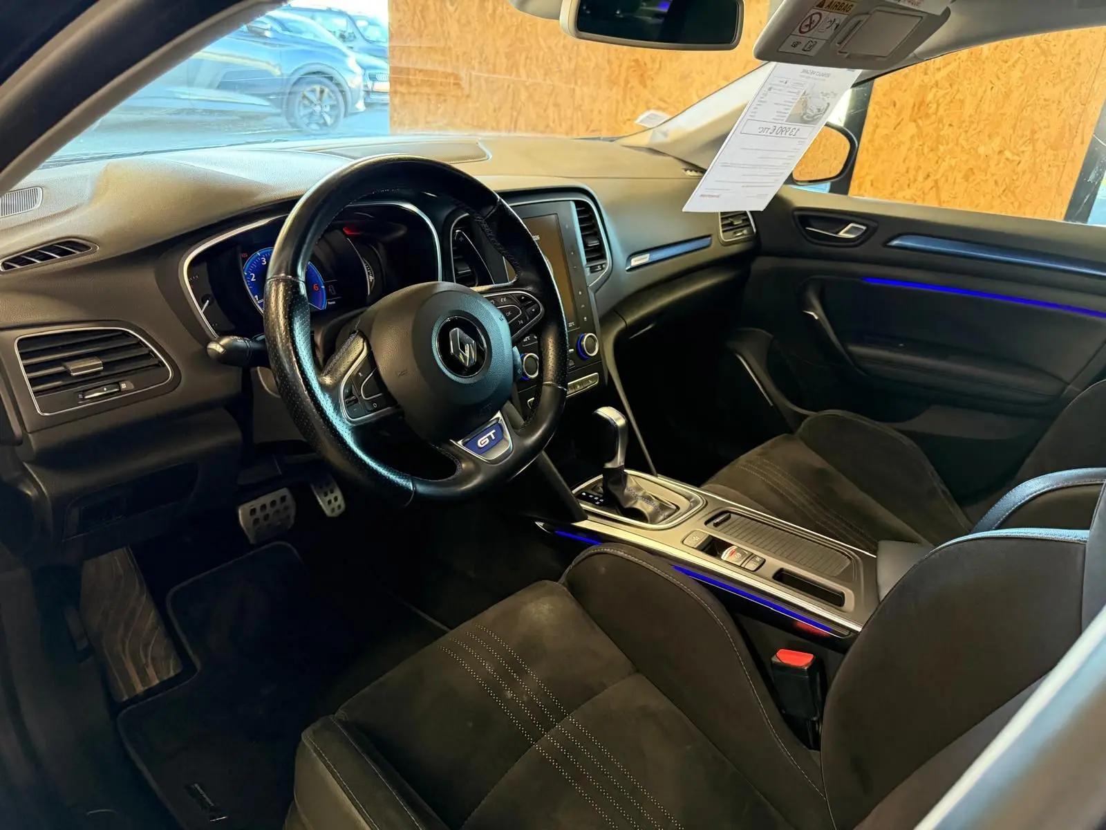 Intérieur noir de Renault Mégane Break GT 2017 vu côté conducteur, avec éclairage d’ambiance bleu et volant GT.