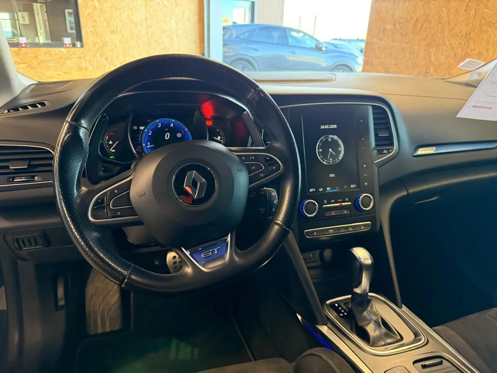 Vue intérieure centrée sur le volant GT et la console centrale avec écran tactile du Renault Mégane Break gris.