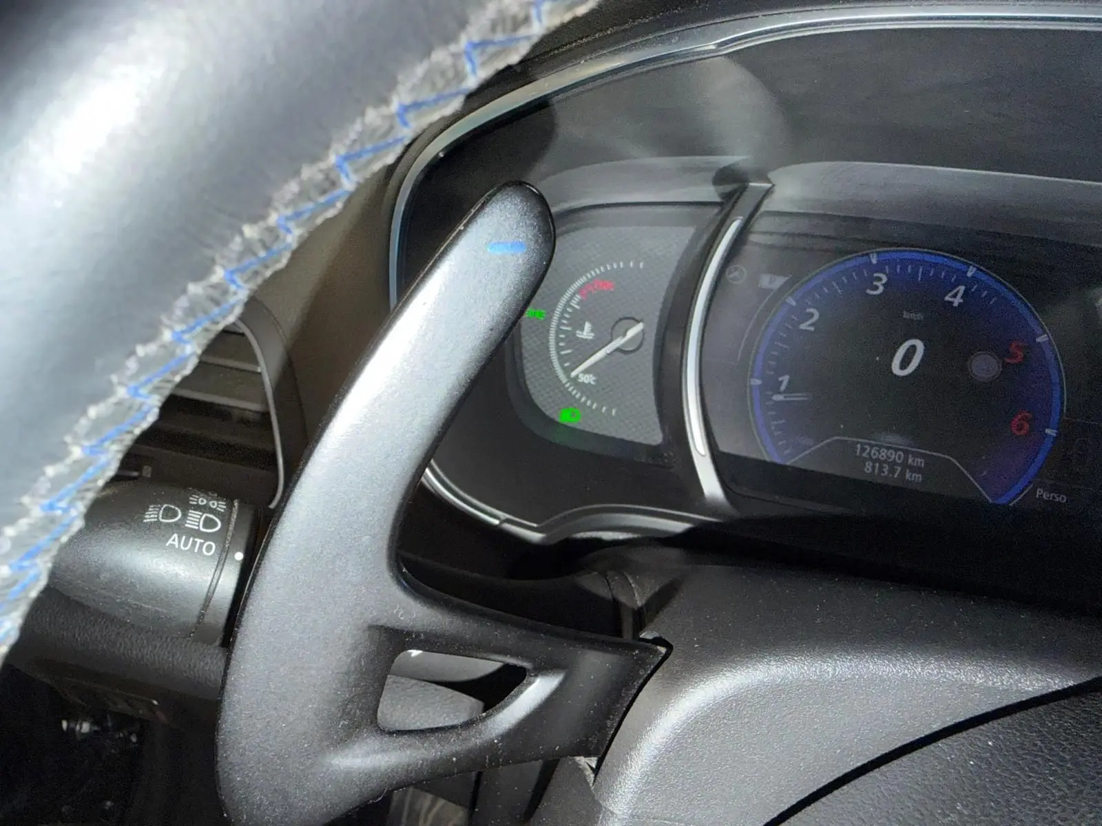 Vue rapprochée du tableau de bord et du volant avec surpiqûres bleues de la Renault Mégane Break GT diesel gris de 2017.