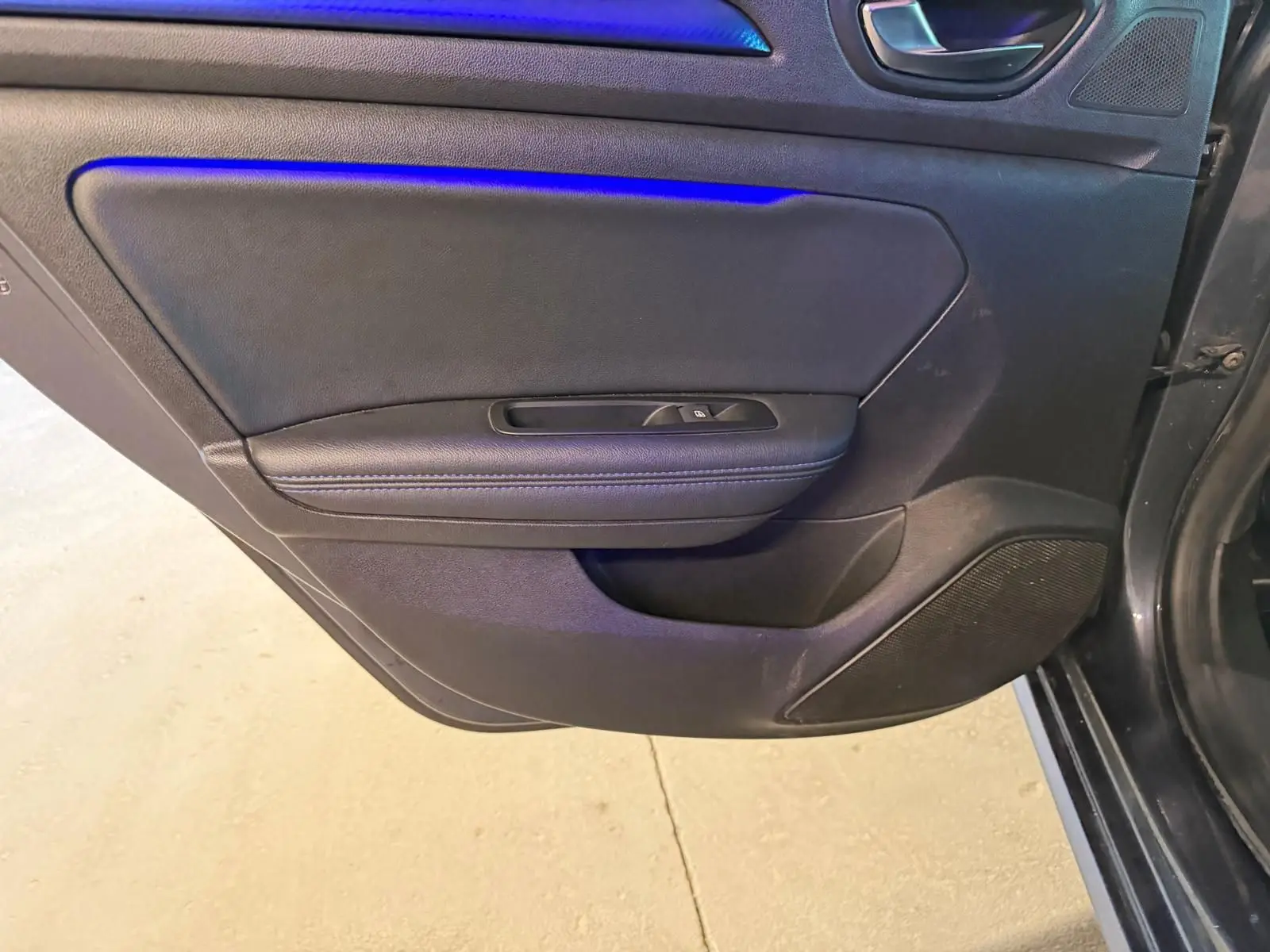 Gros plan sur la porte intérieure côté gauche de la Renault Mégane Break GT 2017, avec garniture noire et commande de fenêtre.