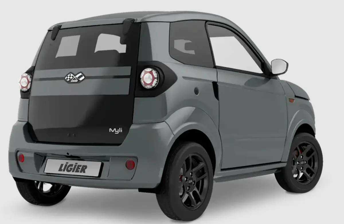 Vue 3/4 arrière droite d'une Ligier Myli gris clair avec jantes alu noires et hayon noir brillant.