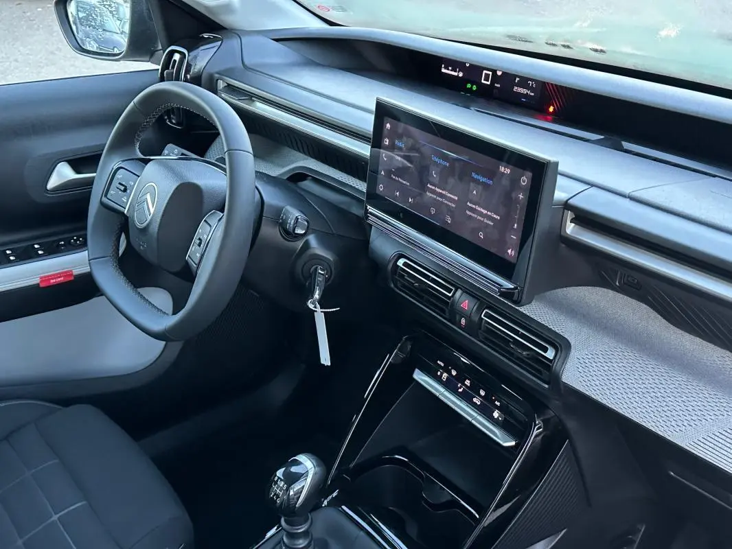 Vue intérieure côté conducteur de la Citroën C3 2025 noire, avec tableau de bord moderne et écran tactile central.