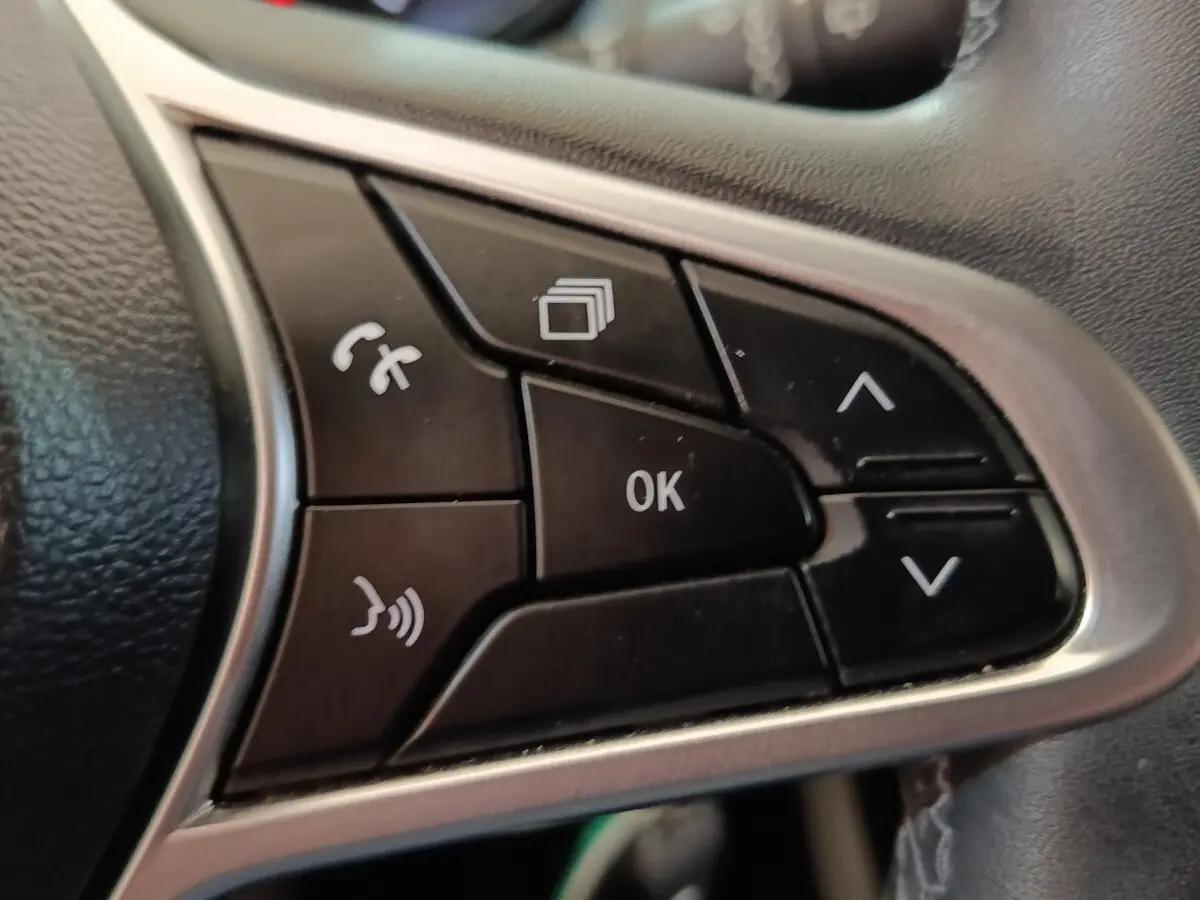 Gros plan sur les commandes multifonctions noires du volant en cuir synthétique d’une Renault Clio Business Blue dCi 100 2022.
