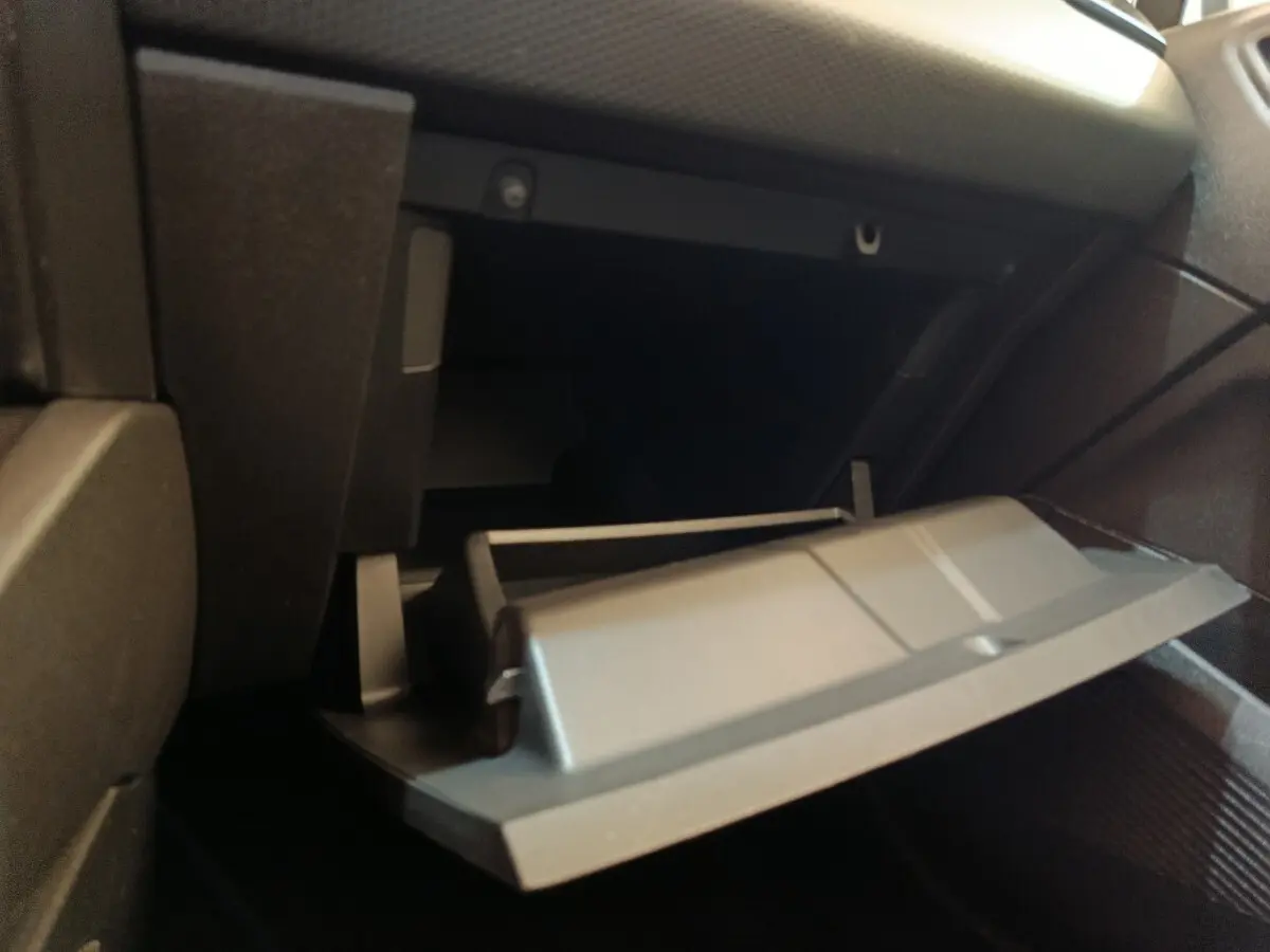 Gros plan sur la boîte à gants ouverte côté passager de la Renault Clio Business Blue dCi 100 blanche de 2022.
