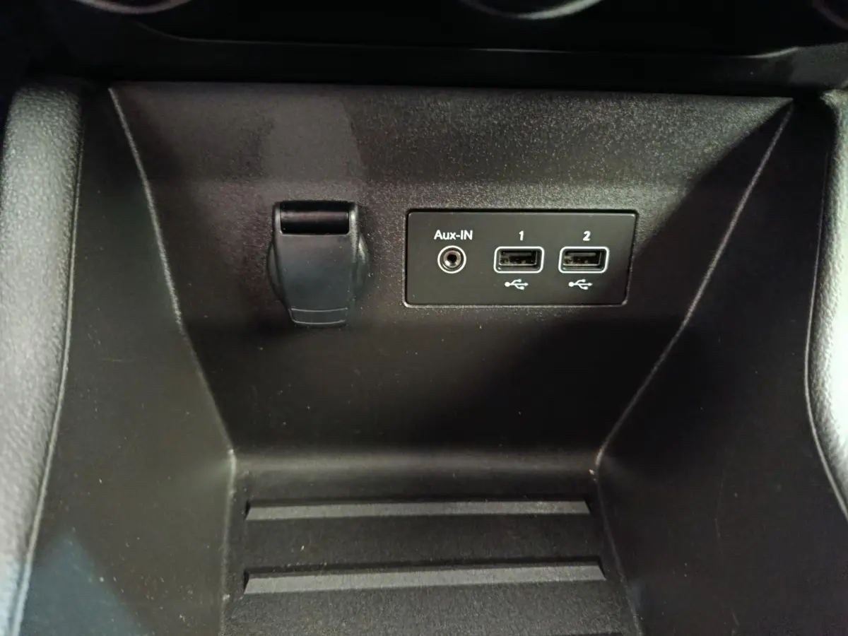 Gros plan sur la prise 12V, port Aux-IN et deux ports USB dans le compartiment avant de la Renault Clio Business Blue dCi 100.