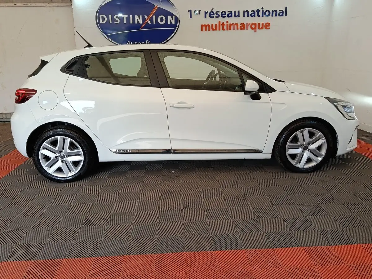 Profil droit d'une Renault Clio Business Blue dCi 100 blanche 2022, avec jantes alliage et logo Clio sur la porte arrière.