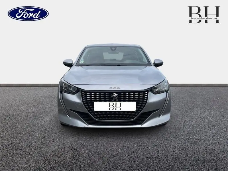 Vue avant d'une Peugeot 208 gris Artense avec calandre noire et phares LED, sur fond neutre avec logos Ford et BH.
