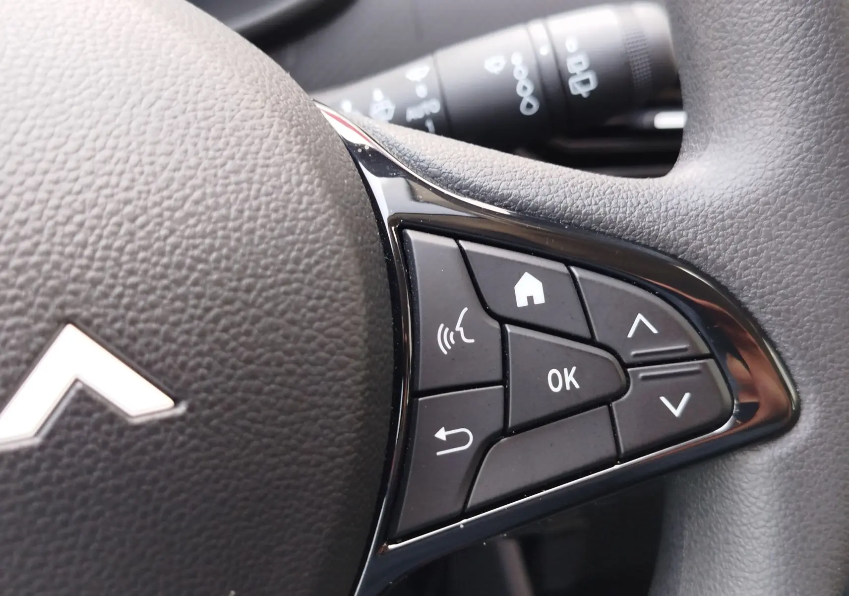Gros plan sur les commandes multifonctions à droite du volant noir de la Dacia Sandero 2025, finition Essentiel.