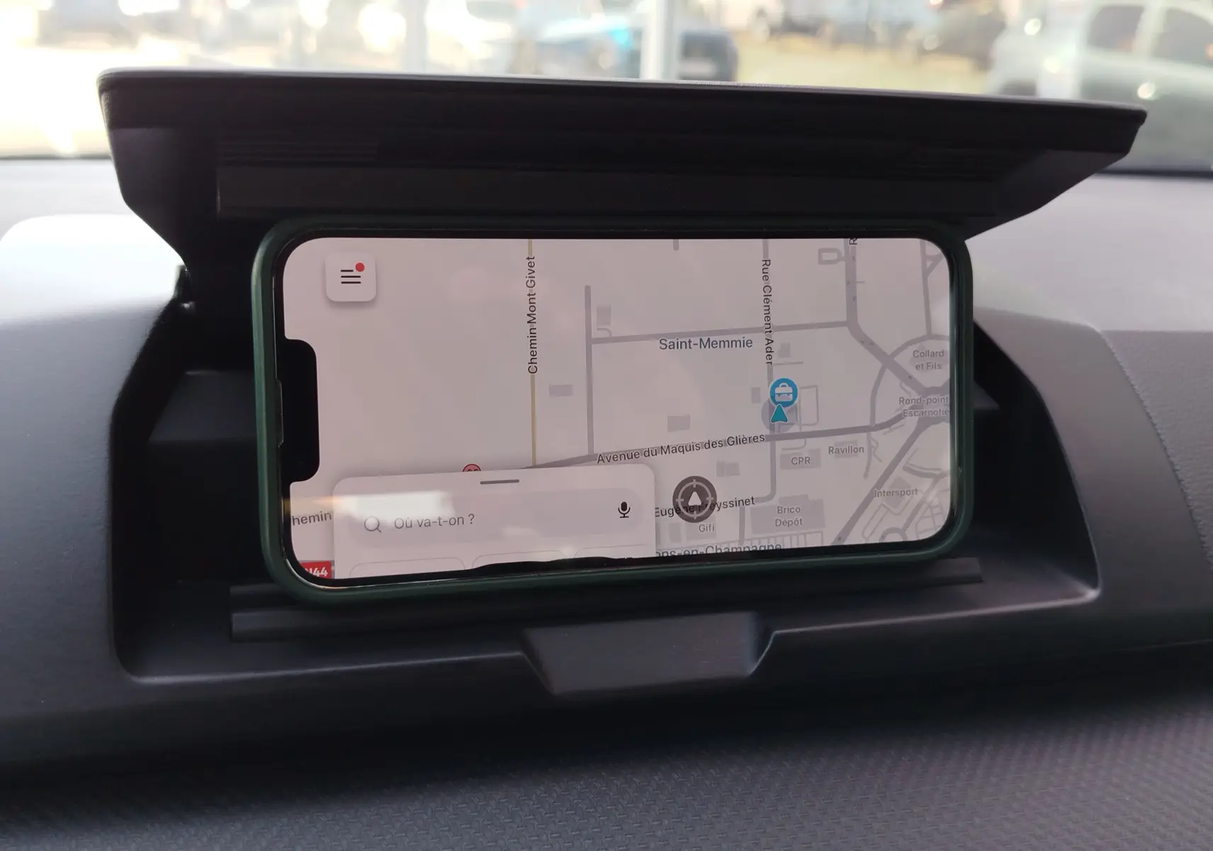 Vue intérieure du tableau de bord d'une Dacia Sandero 2025 avec smartphone affichant une carte GPS intégrée.