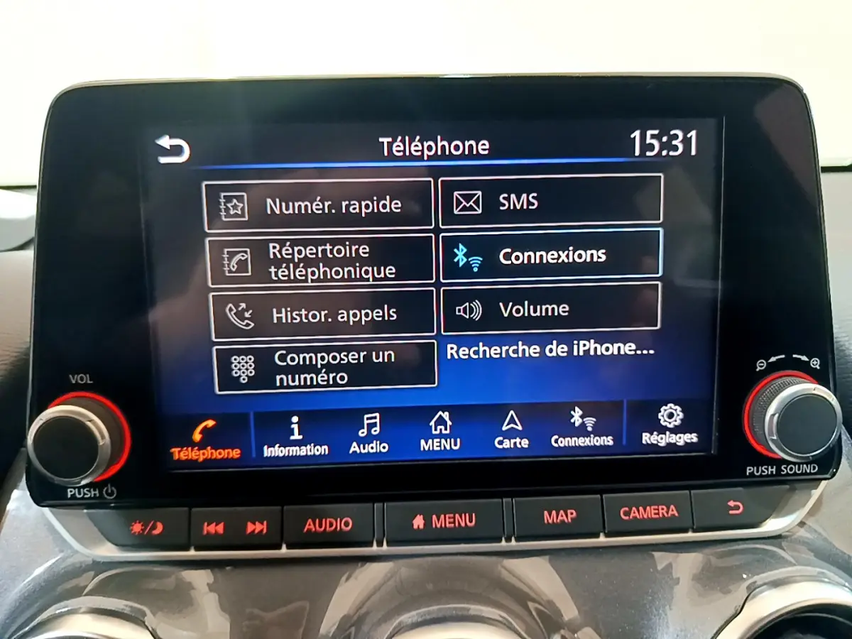 Écran tactile central du Nissan Juke Hybrid 2023 affichant le menu téléphone avec commandes audio et caméra en dessous.