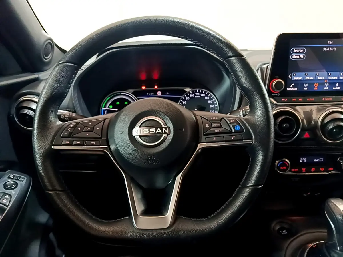 Vue rapprochée du volant cuir noir Nissan Juke Hybrid 143 Business+ 2023 avec tableau de bord et écran tactile.