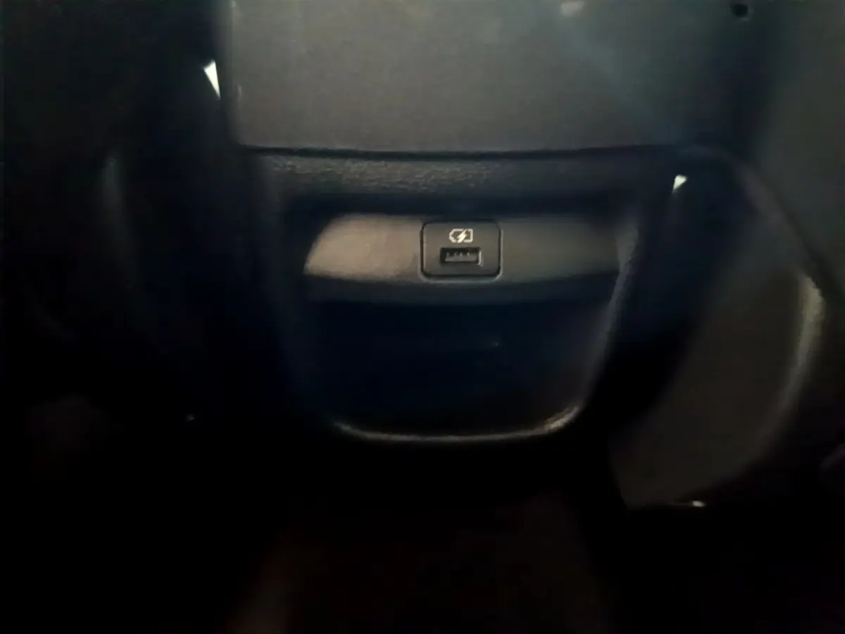 Prise USB de recharge rapide en gros plan dans l'habitacle du Nissan Juke Hybrid 143 Business+ gris foncé 2023.