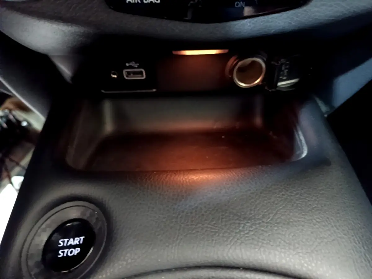 Bouton démarrage Start/Stop et prise USB avec allume-cigare dans le rangement central du Nissan Juke Hybrid 2023.