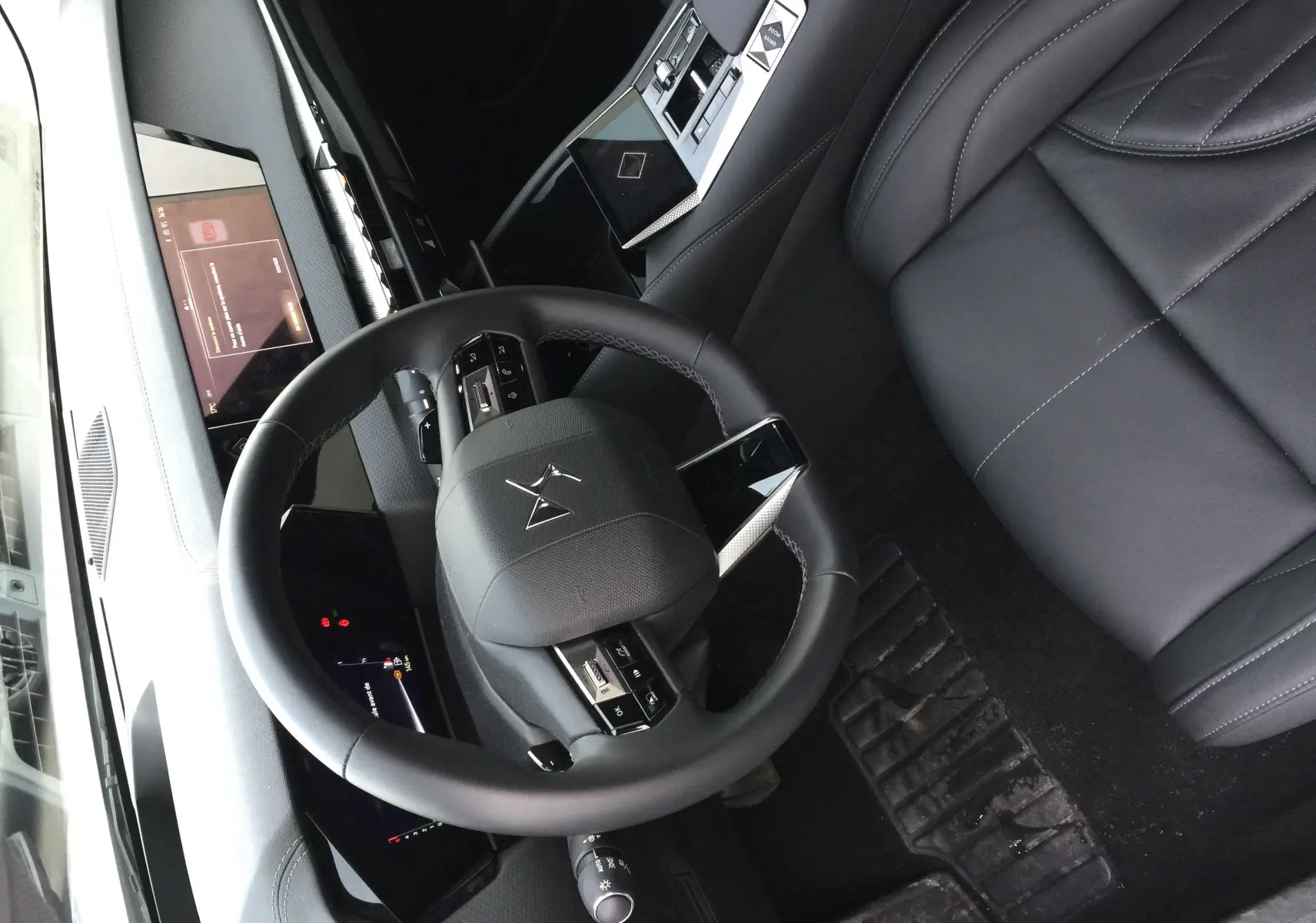 Vue plongeante sur l'intérieur noir cuir du DS4 2024, avec volant multifonction et tableau de bord numérique.