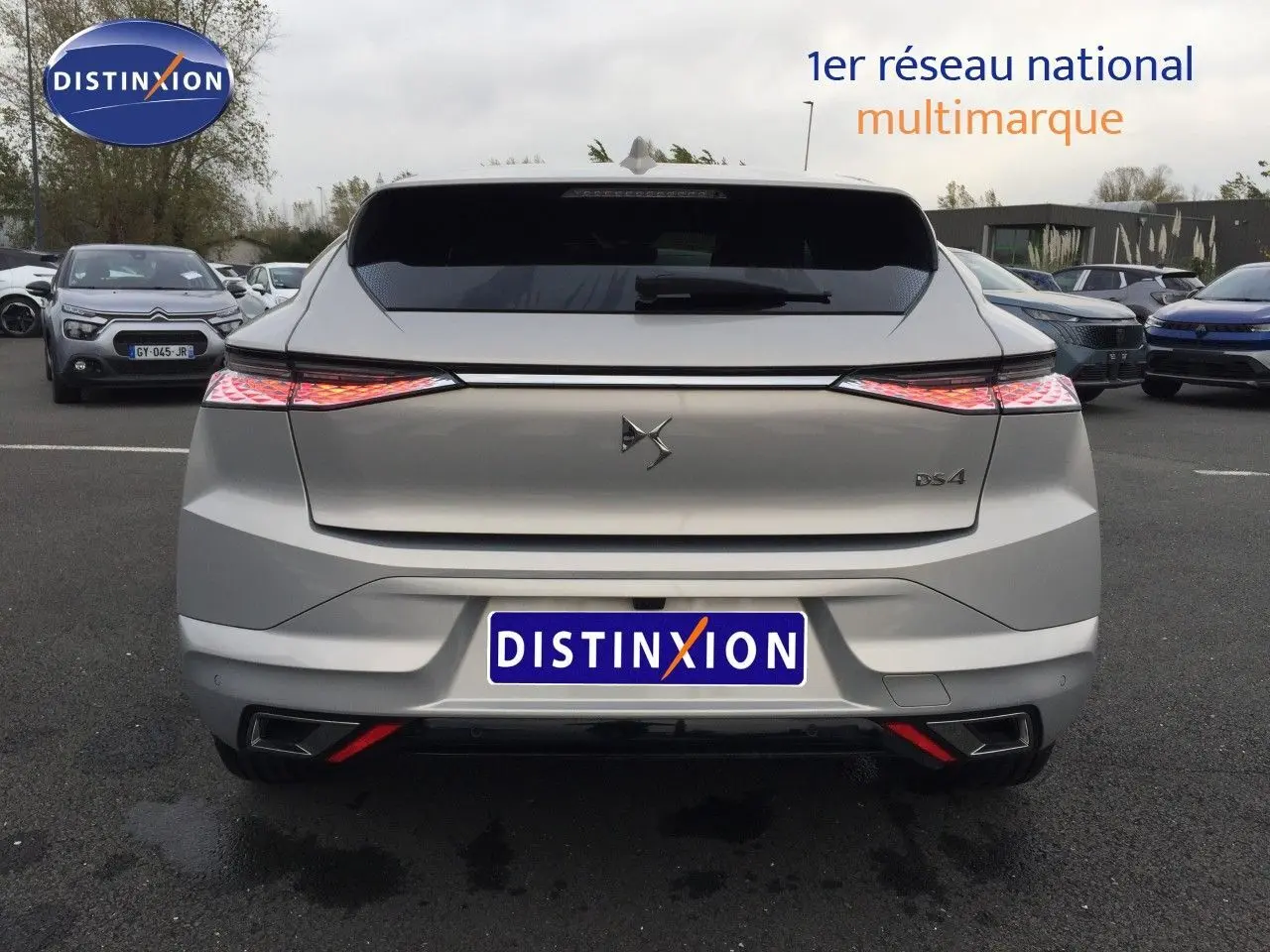 Vue arrière d'une DS4 2024 couleur Eph Crystal, avec feux arrière allumés et logo DS bien visible.