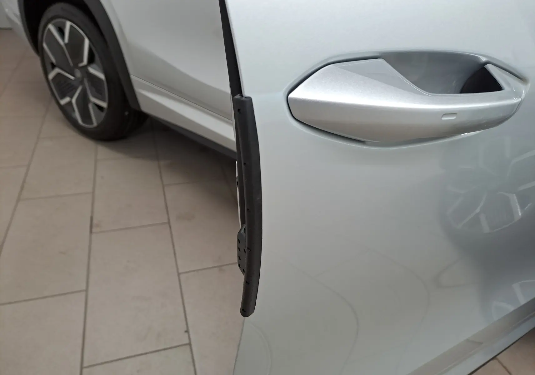 Poignée de porte côté droit d’un Skoda Kodiaq gris argent 2025 avec jante alliage visible en arrière-plan.