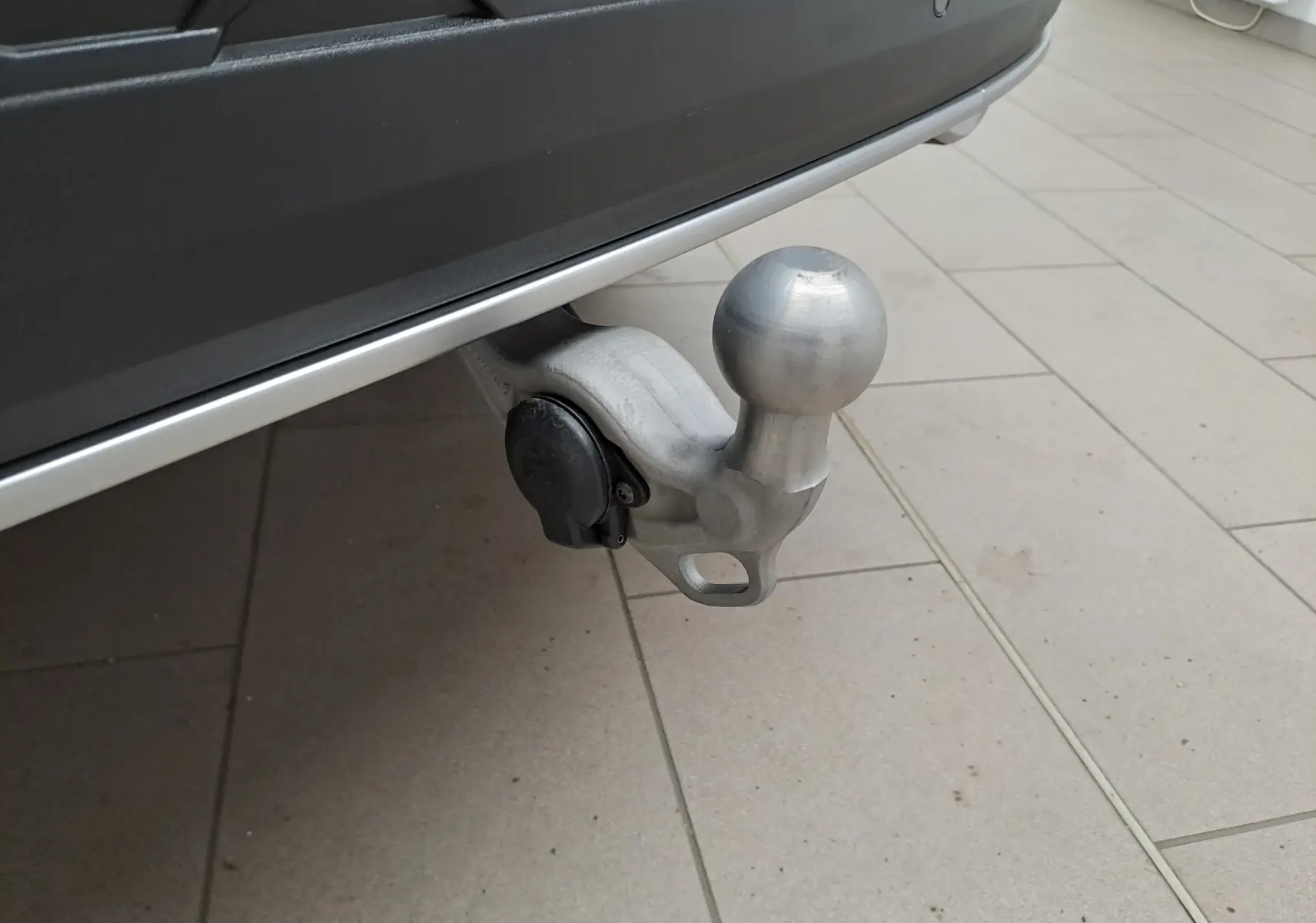 Gros plan sur le crochet d'attelage pivotant gris argent du Skoda Kodiaq 2025, vue côté arrière droit.