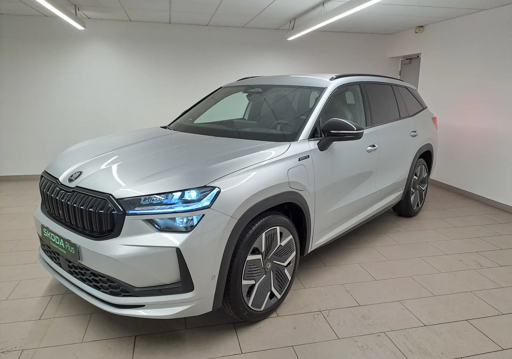Vue 3/4 avant droit du Skoda Kodiaq gris argent avec calandre noire et jantes alliage 20 pouces en intérieur neutre.
