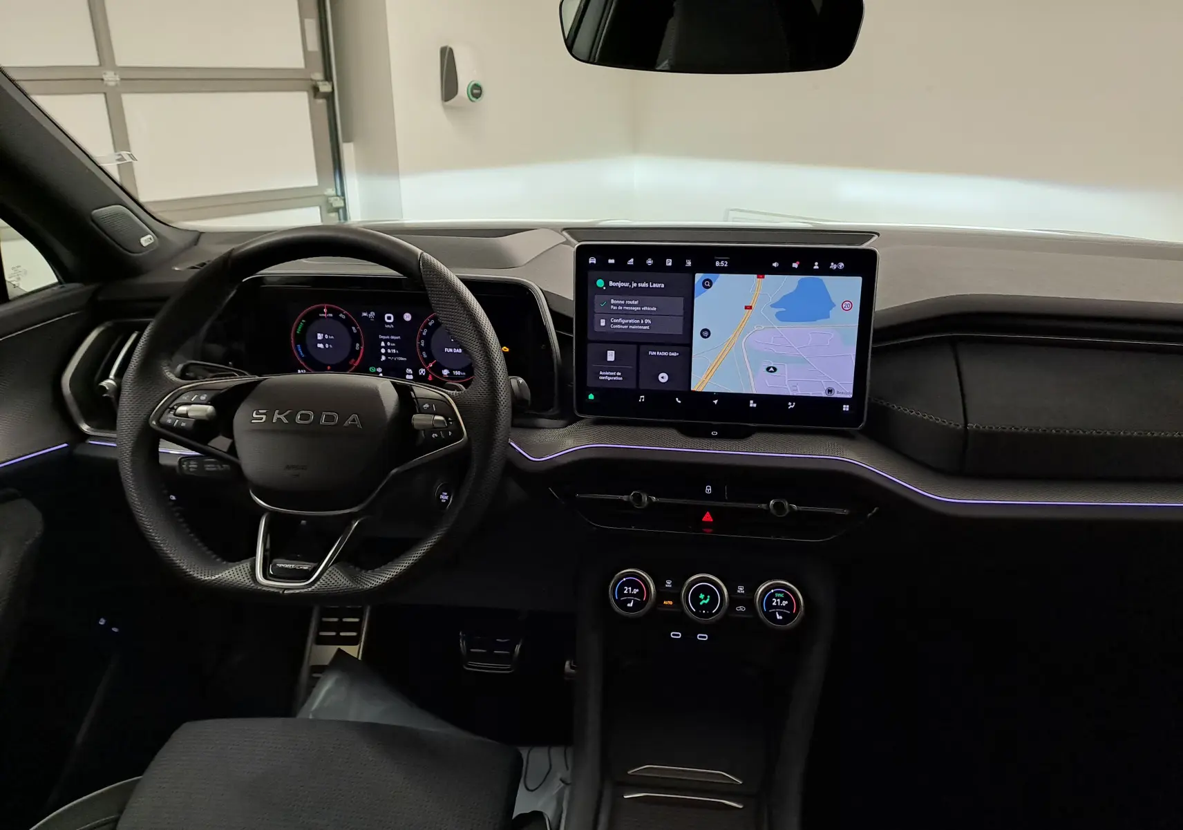 Vue intérieure du tableau de bord et volant noir du Skoda Kodiaq 2025 avec écran tactile central et affichage numérique.