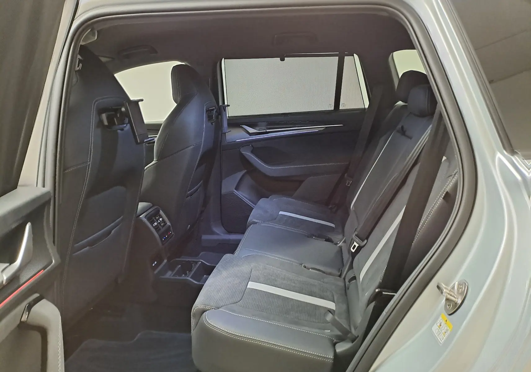 Vue intérieure côté droit des sièges arrière en cuir noir avec surpiqûres claires du Skoda Kodiaq gris argent 2025 Sportline.
