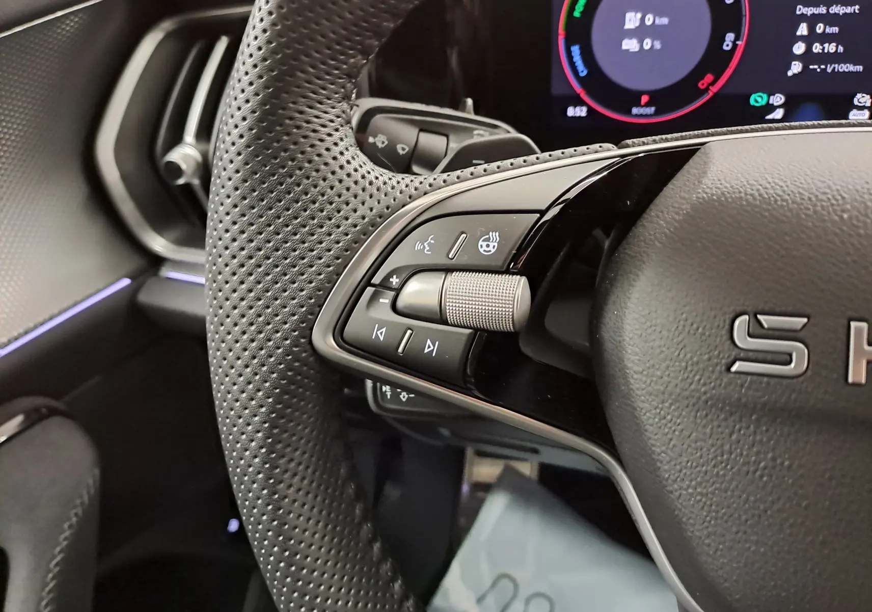 Gros plan sur le volant perforé du Skoda Kodiaq 2025 avec commandes intégrées et affichage numérique partiel.