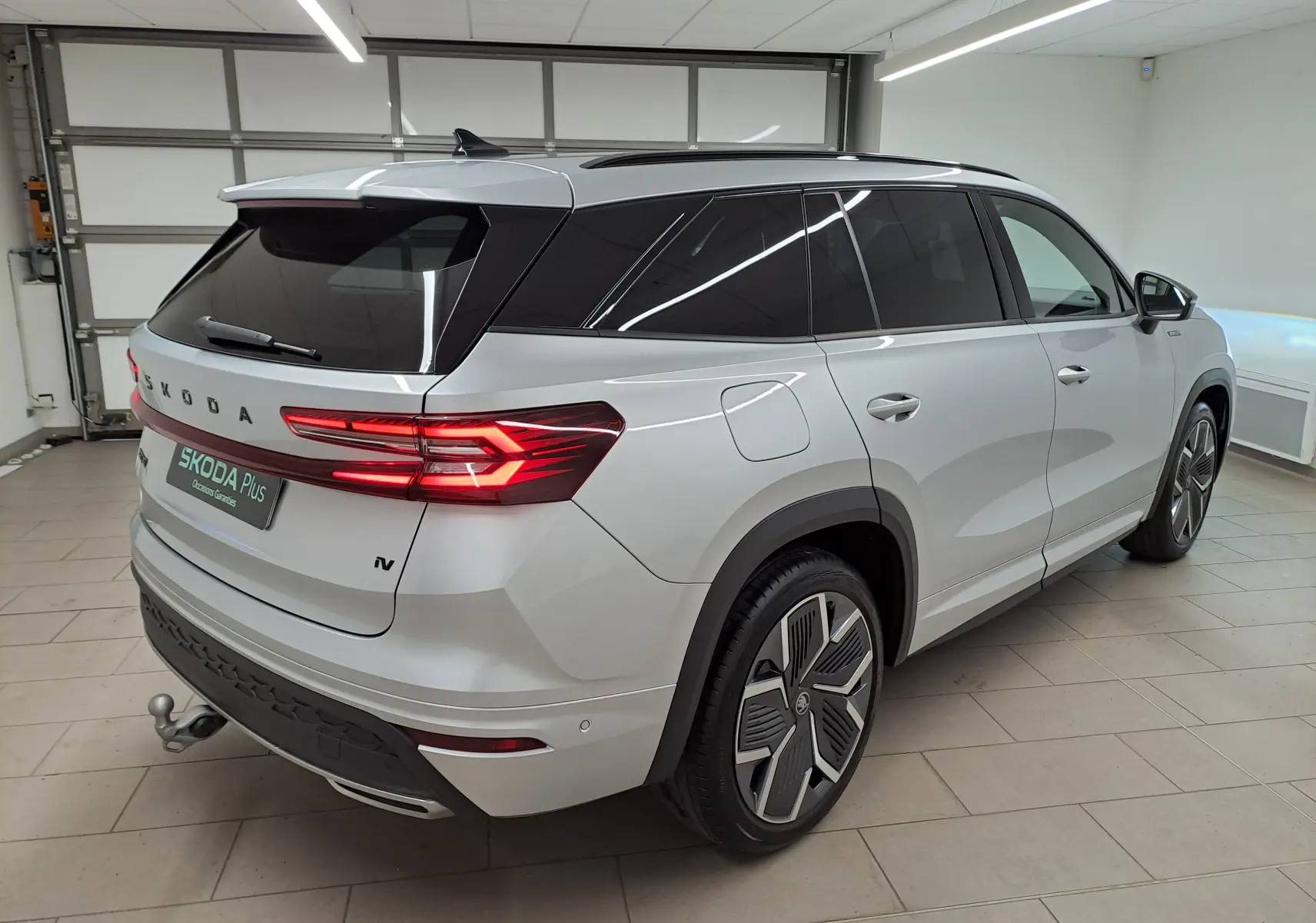 Vue 3/4 arrière droite du Skoda Kodiaq gris argent avec jantes 20 pouces et crochet d'attelage pivotant.