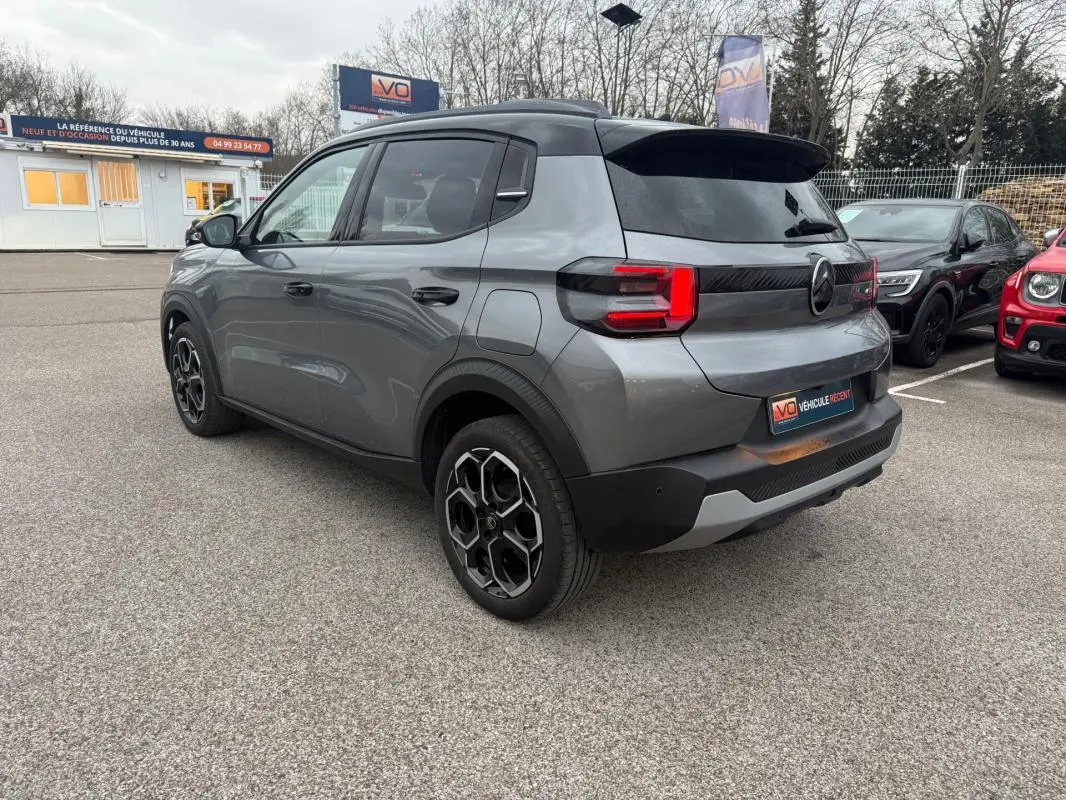 Citroën C3 Turbo 100 ch gris vue 3/4 arrière droit avec jantes alliage 17 pouces et barres de toit noires.