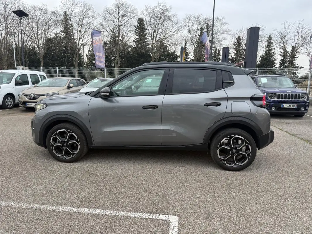 Profil côté gauche d'une Citroën C3 gris 2025 avec jantes alliage 17 pouces et barres de toit noires.