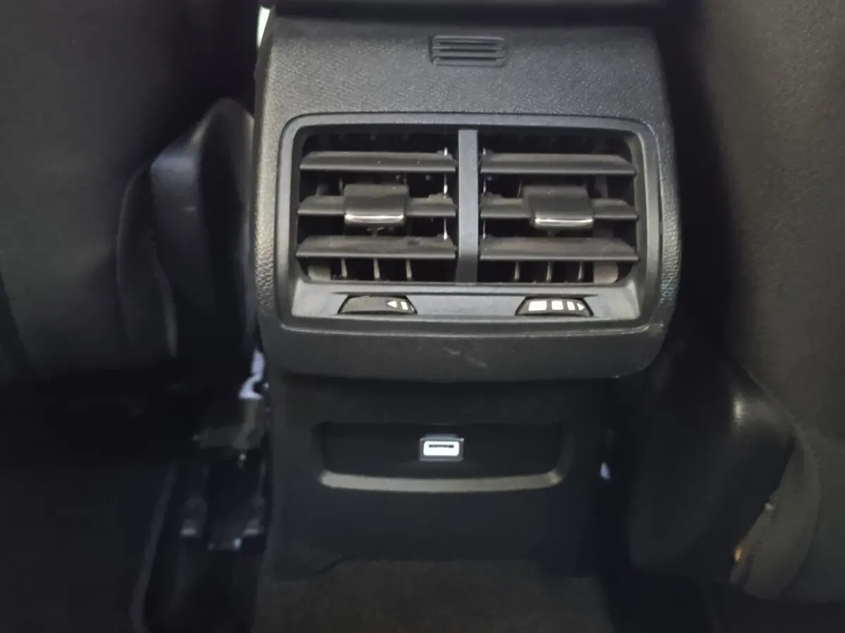 Vue rapprochée des aérateurs arrière noirs et port USB du Citroën C4 BlueHDi 130 gris foncé, intérieur arrière.