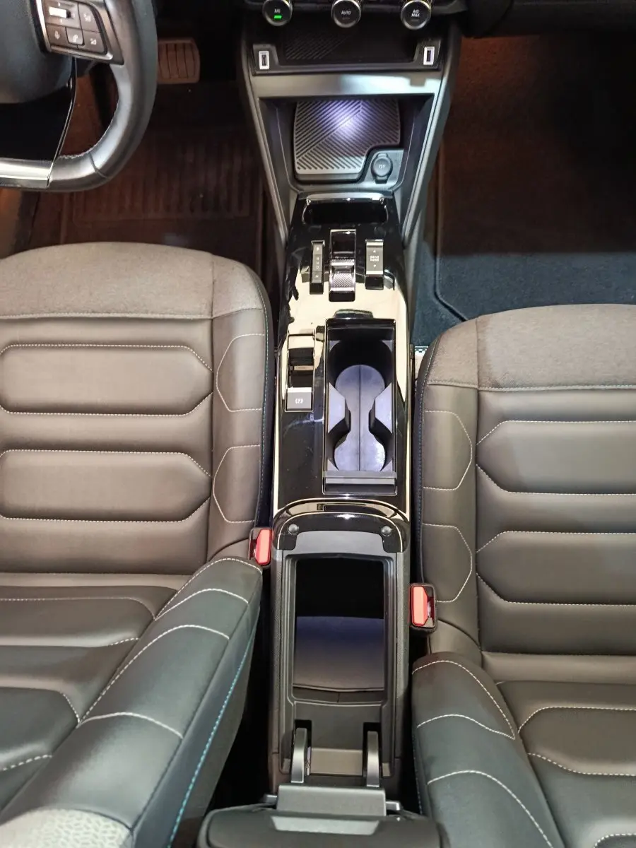 Vue plongeante sur la console centrale noire et les sièges gris foncé en cuir de la Citroën C4 Shine 2022.