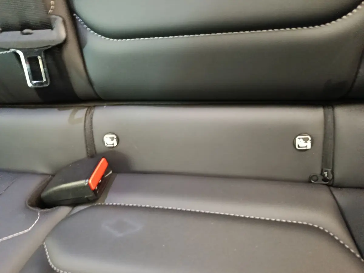 Détail de la banquette arrière noire avec ceintures et fixations Isofix visibles dans une Citroën C4 gris foncé.