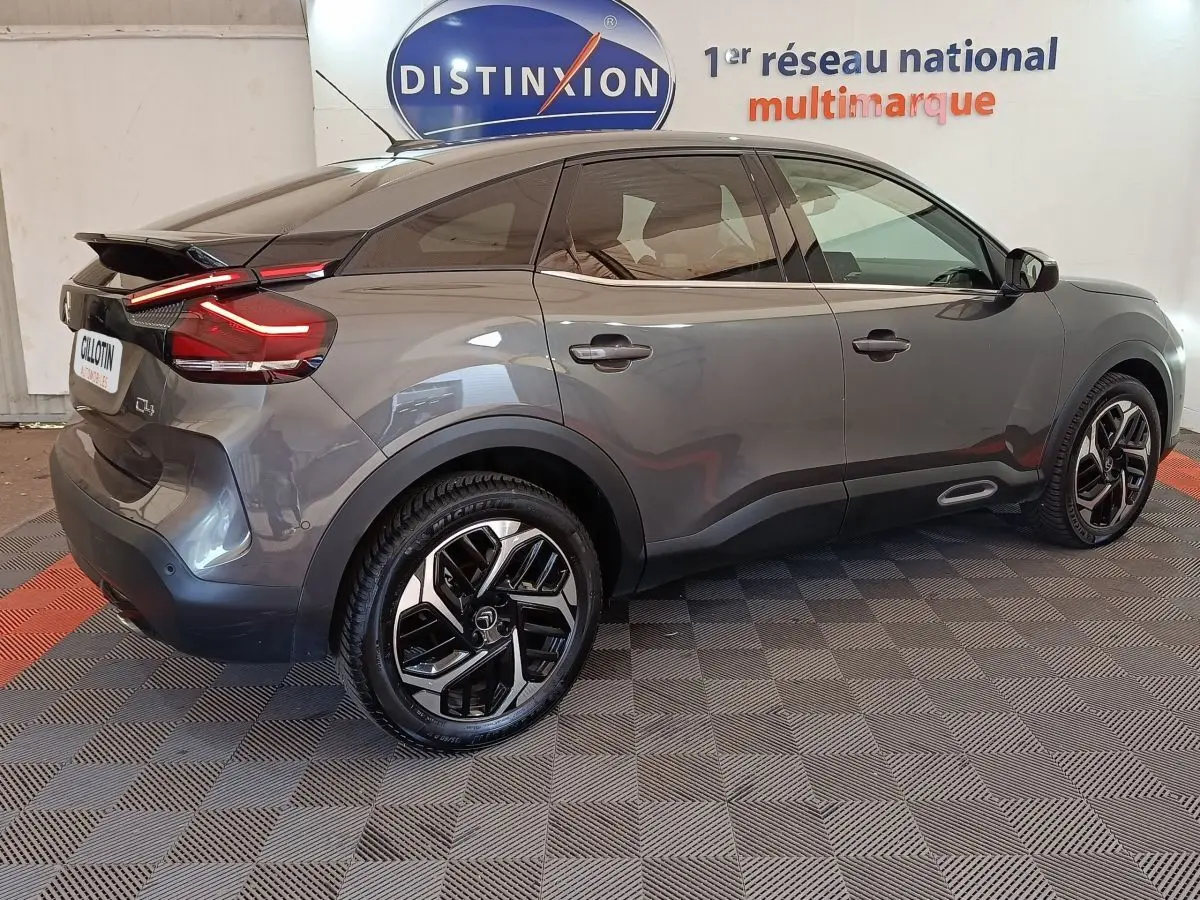 Vue côté droit arrière d'une Citroën C4 gris foncé 2022 avec feux arrière LED et jantes alliage bicolores.