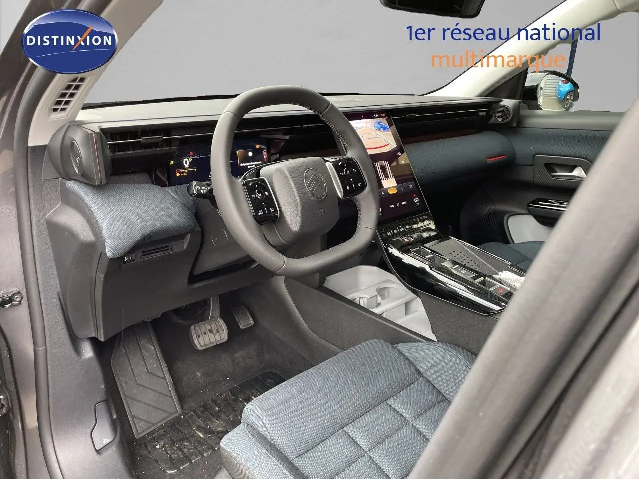Vue intérieure côté conducteur du Citroën C5 Aircross Hybrid 2026, tableau de bord moderne et sièges tissu gris.