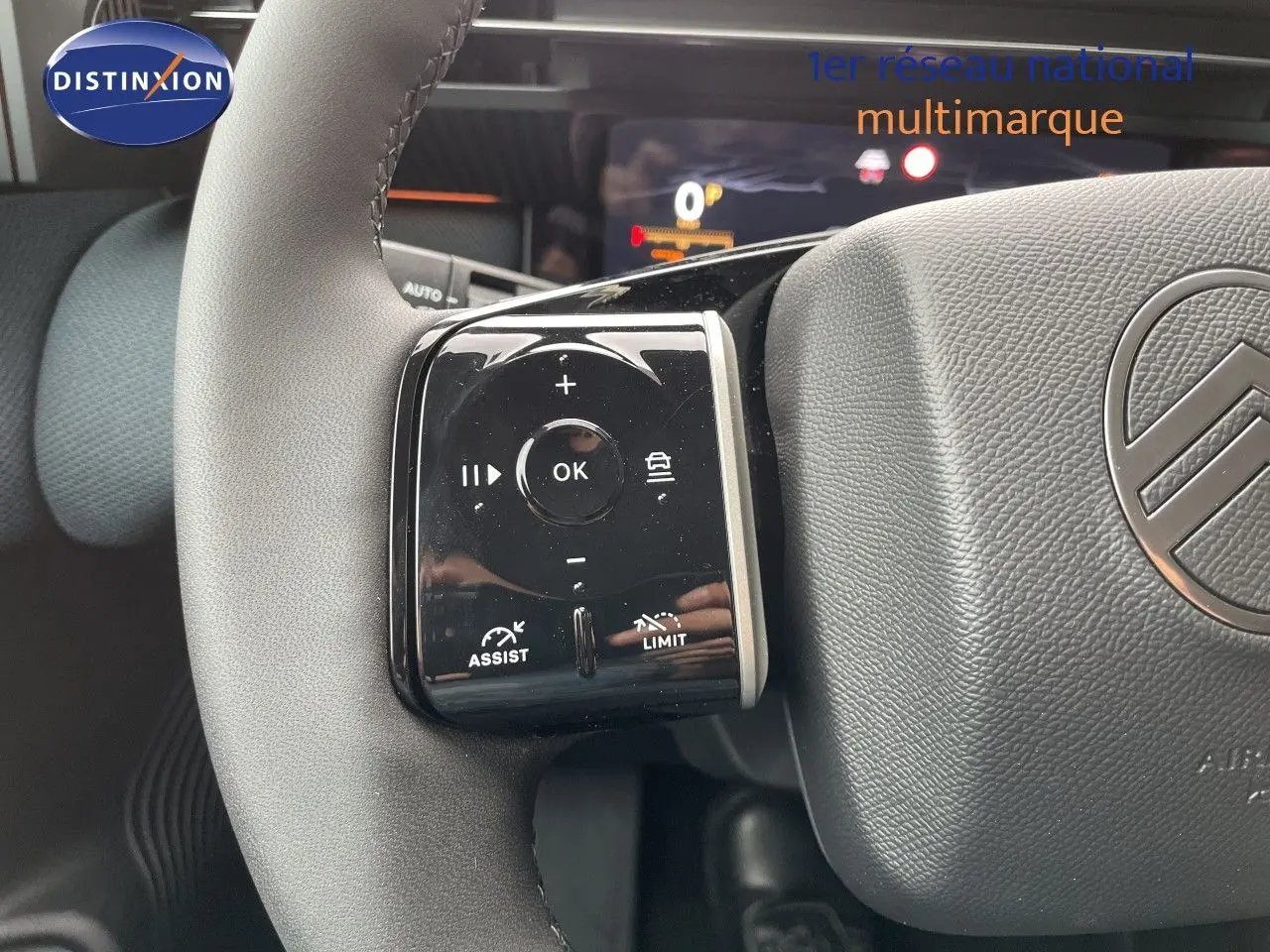 Gros plan sur les commandes à gauche du volant gris du Citroën C5 Aircross Hybrid 2026, avec tableau de bord numérique en arrière-plan.