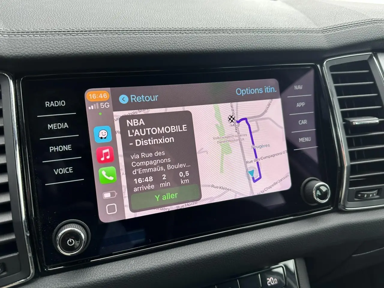 Écran tactile central du Skoda Kodiaq blanc glacier 2024 affichant la navigation avec itinéraire et options.
